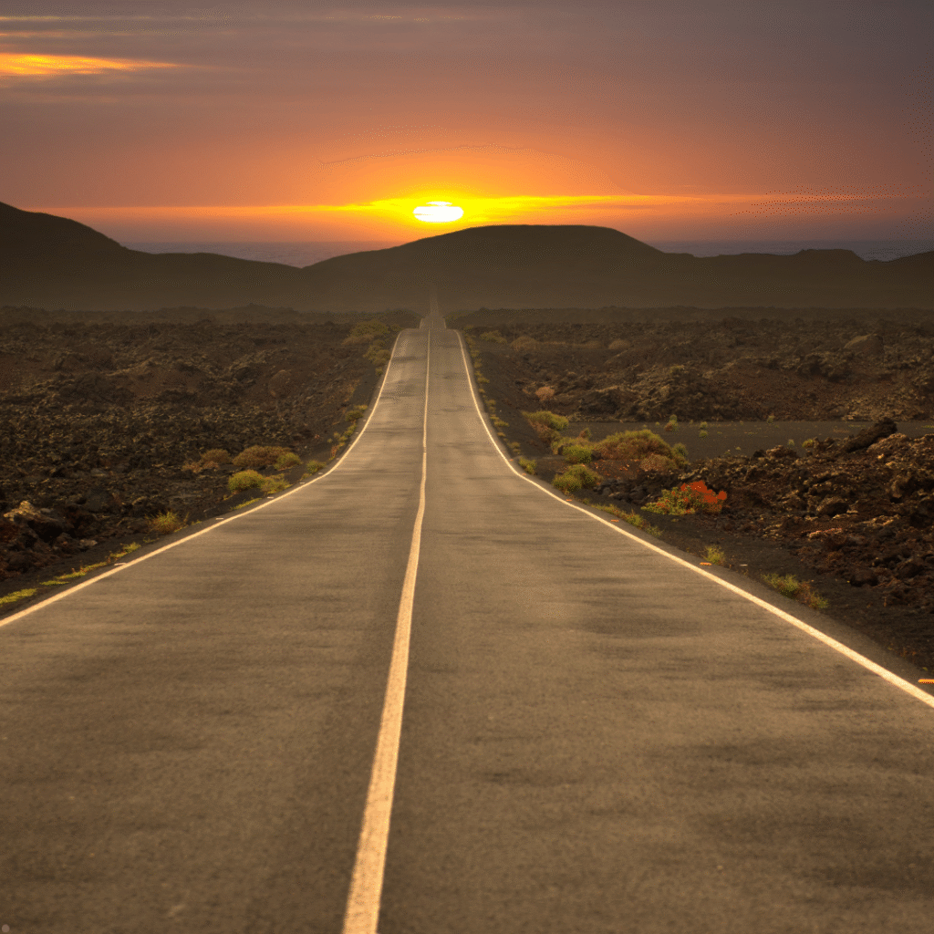 Open road leading into the horizon at sunset, symbolizing new journeys and endless possibilities.