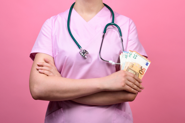 Nurses earn in Canada - white smiling nurse holding notes